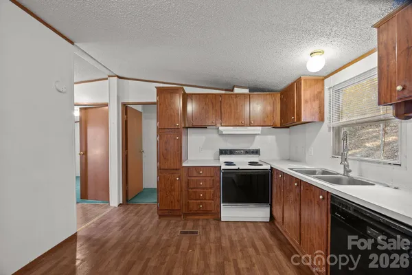a large kitchen with wooden floor and stainless steel appliances