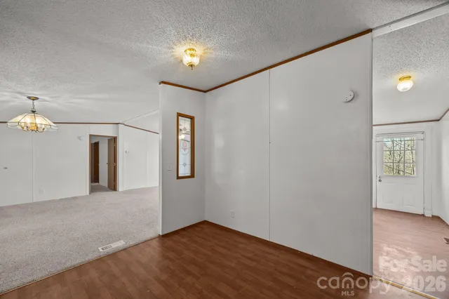 an empty room with windows and ceiling fan