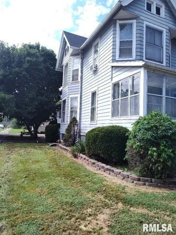 a view of a house with a yard and plants