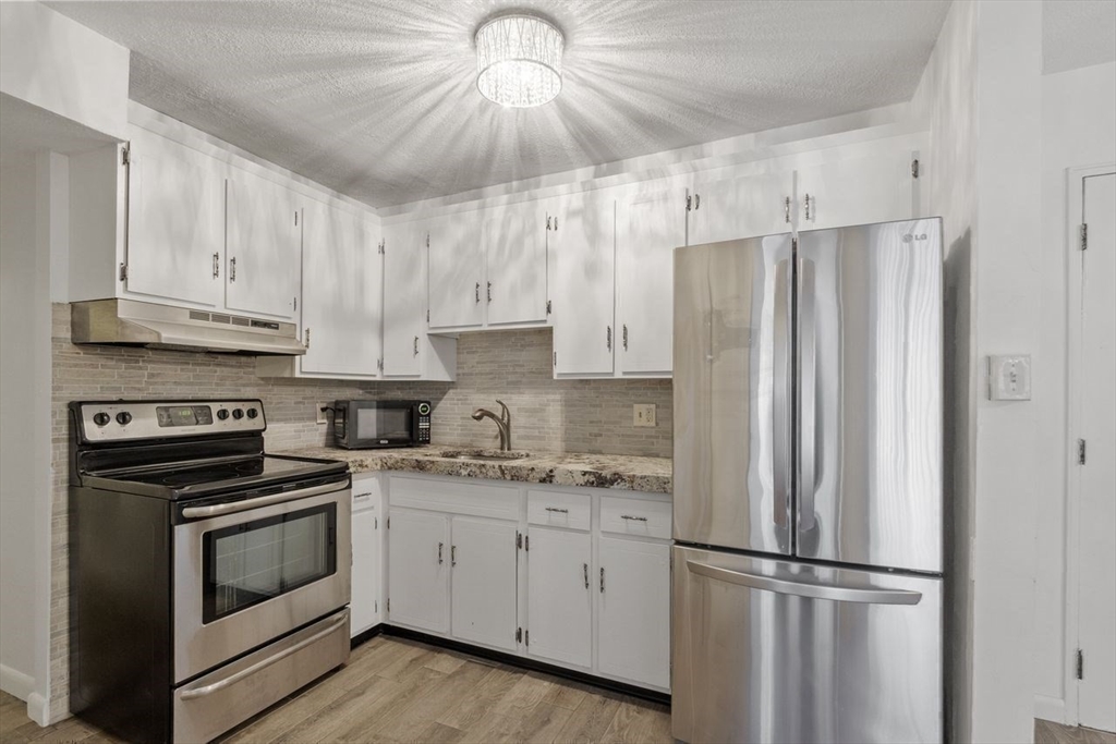 a kitchen with stainless steel appliances white cabinets and a refrigerator