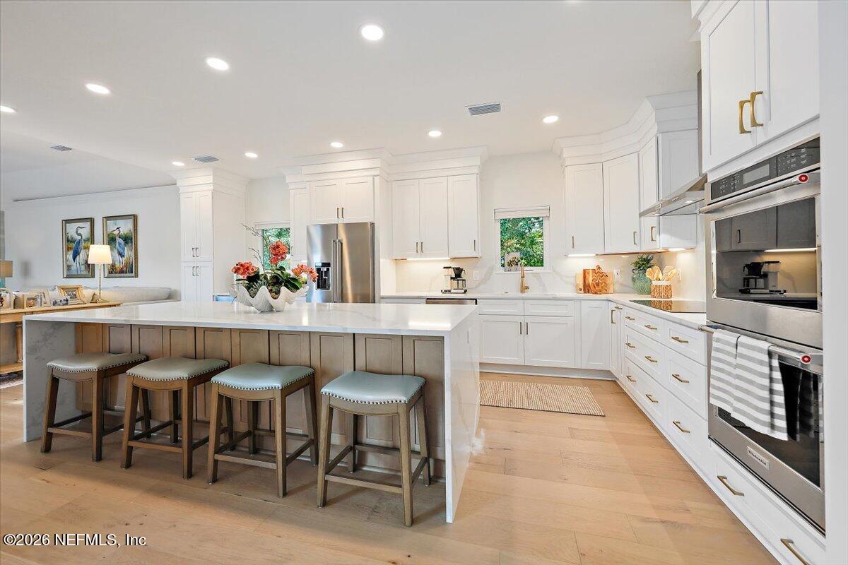 2253 Beachcomber Trail Atlantic Beach, FL 32233 - Photo 9 of 42 a kitchen with white cabinets and chairs