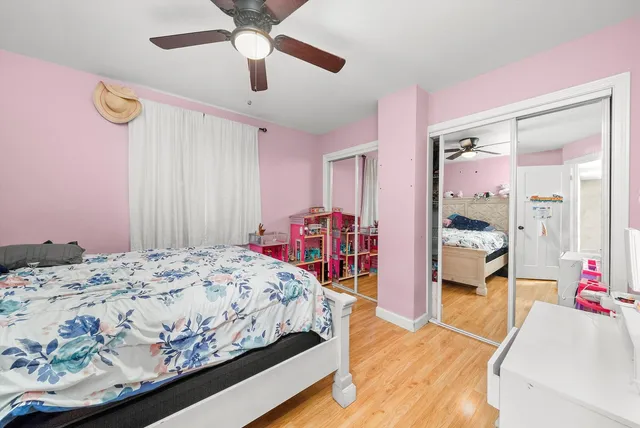 a bedroom with a bed closet and wooden floor