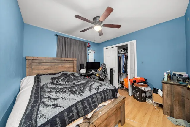 a bed room with a bed and a ceiling fan