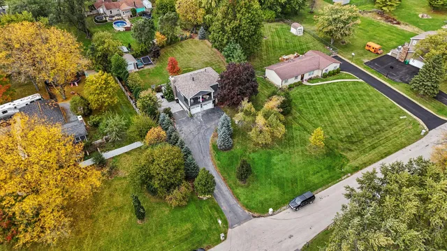 an aerial view of residential house with outdoor space and trees all around