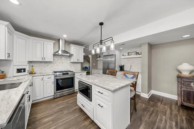 a kitchen with a stove and wooden floor