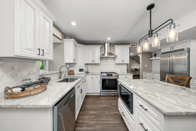 a kitchen with stainless steel appliances granite countertop a sink stove and refrigerator