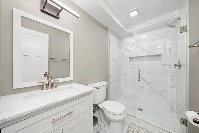 a bathroom with a sink a toilet and shower