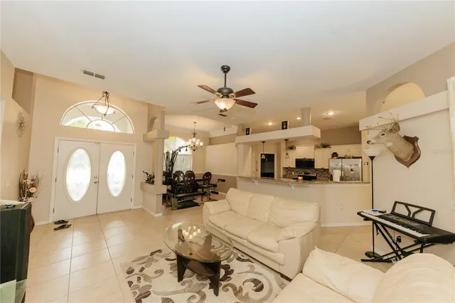 a living room with kitchen furniture and a chandelier