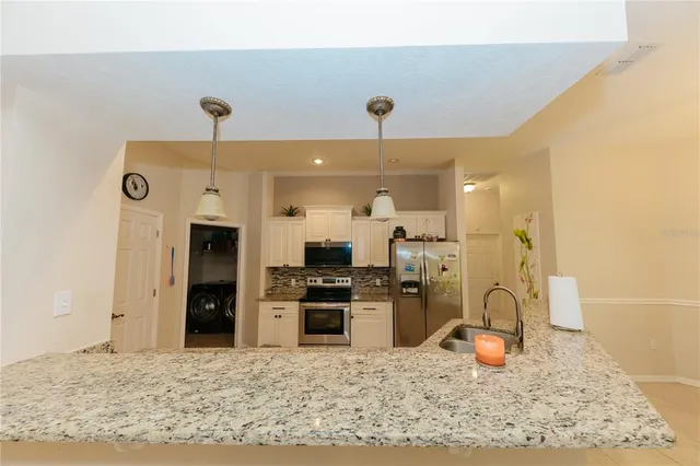 a view of a kitchen with a stove a refrigerator and a sink