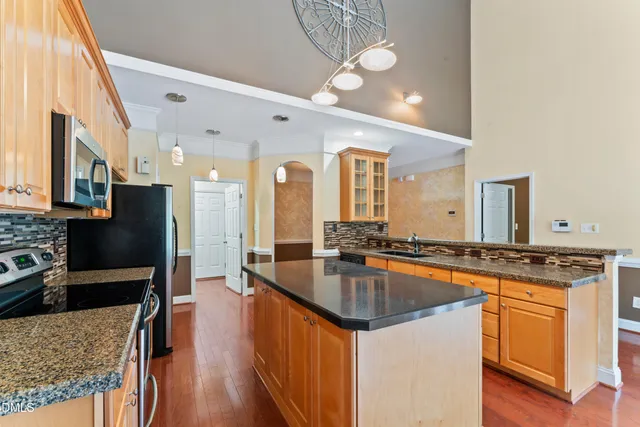 a kitchen with granite countertop a sink stove and refrigerator