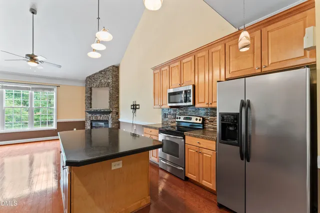 a kitchen with stainless steel appliances granite countertop a refrigerator a stove a sink dishwasher a refrigerator white cabinets and wooden floor