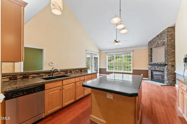 a kitchen with granite countertop a sink stove and cabinets