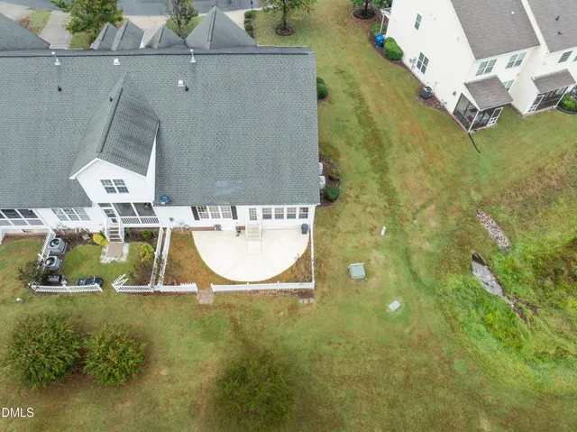 an aerial view of a house with swimming pool and large trees
