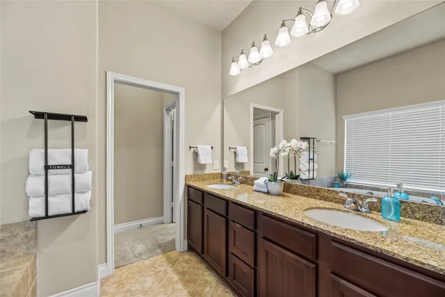 a bathroom with a granite countertop sink a large mirror and a shower