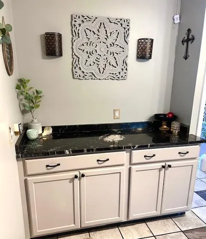 a close view of a stove a microwave and a potted plant on the kitchen counter