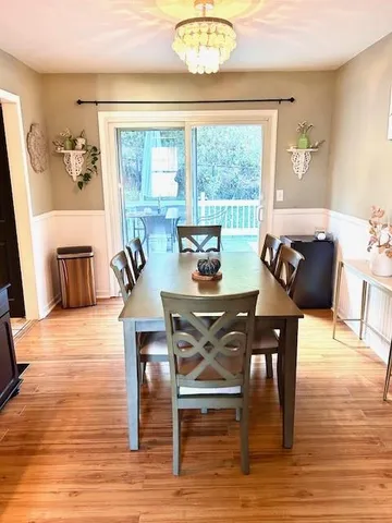 a view of a dining room with furniture a chandelier and wooden floor