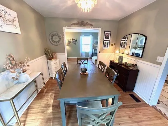 a view of a dining room with furniture a rug and wooden floor