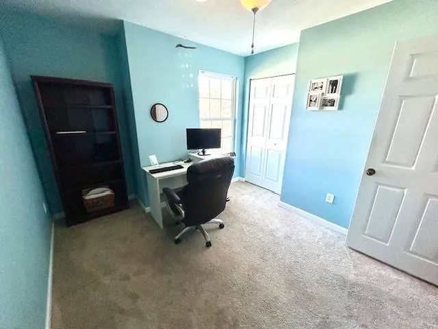 a view of a workspace with furniture and a window