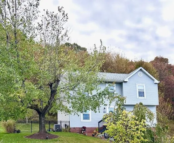 a view of a house with a yard and potted plants