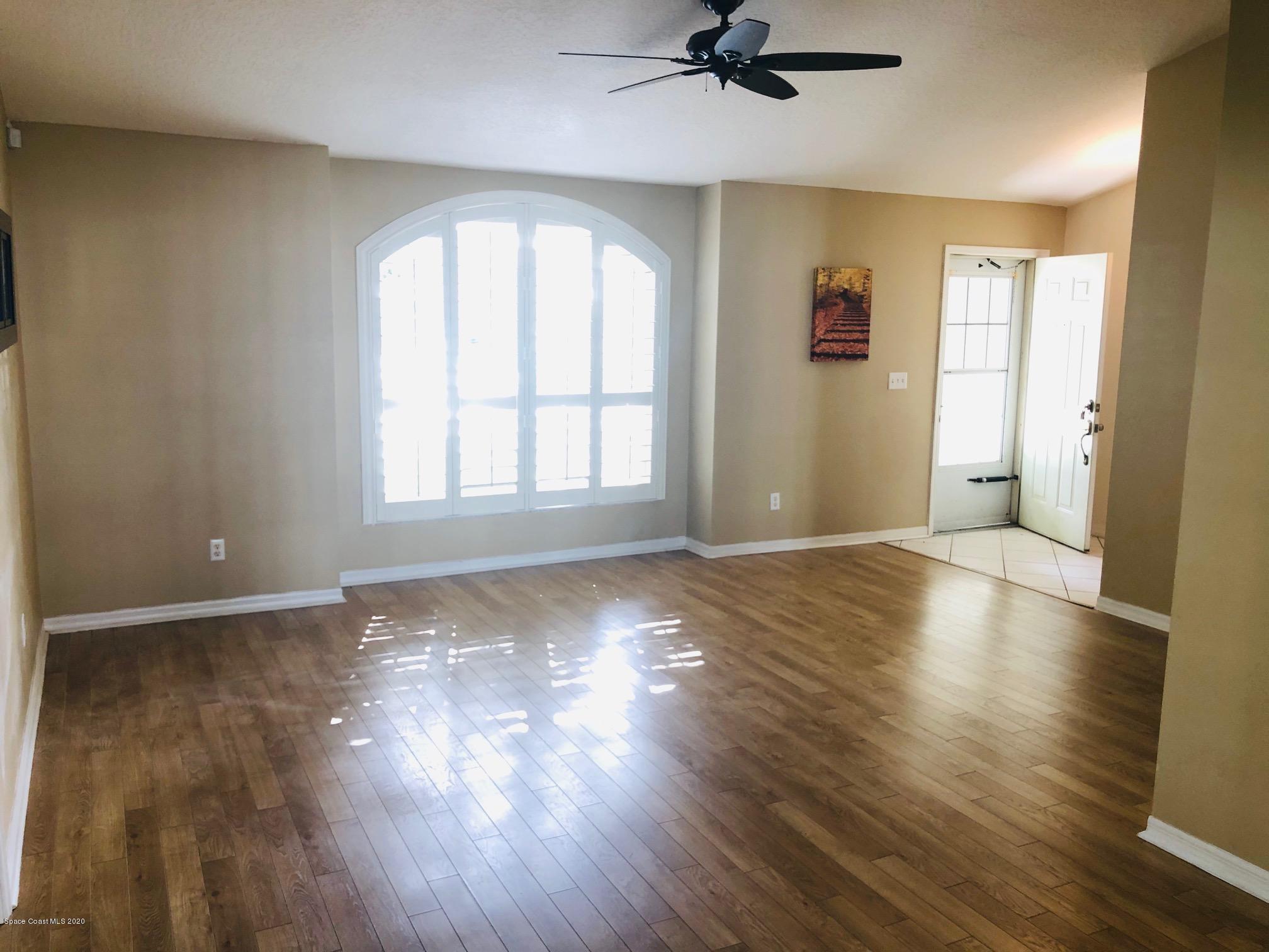 1256 Winding Meadows Road Rockledge, FL 32955 - Photo 4 of 16 a view of an empty room with a window and wooden floor