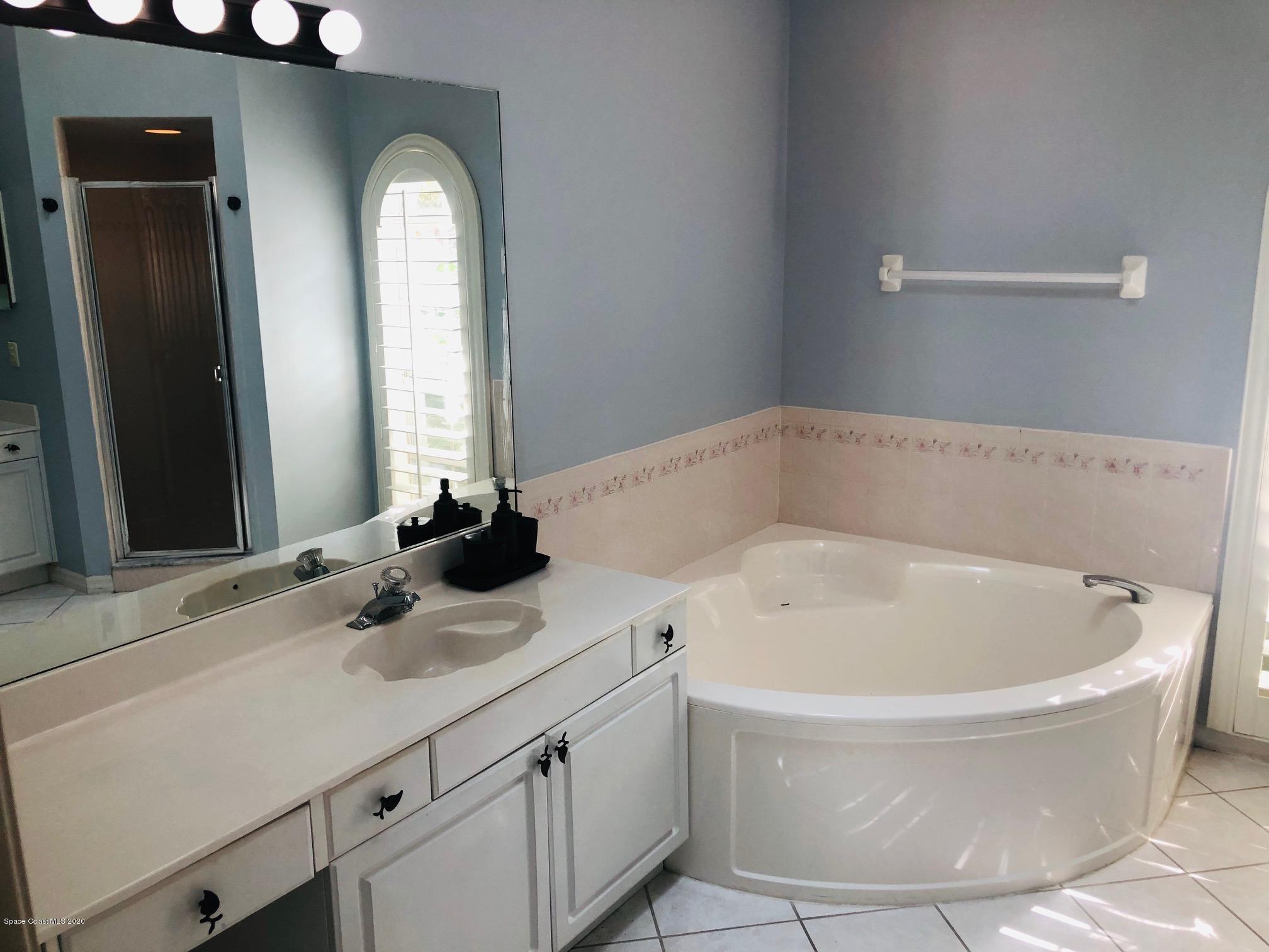 1256 Winding Meadows Road Rockledge, FL 32955 - Photo 10 of 16 a bathroom with a white tub sink and vanity