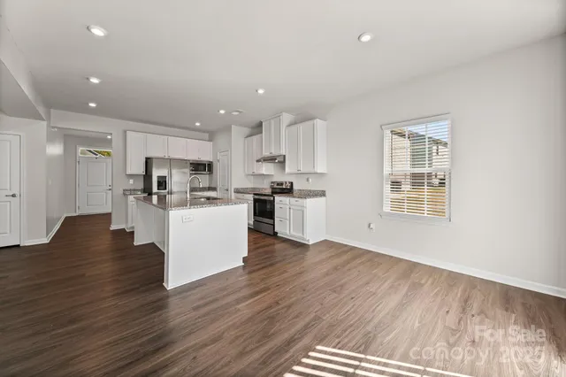 a view of kitchen with wooden floor and electronic appliances