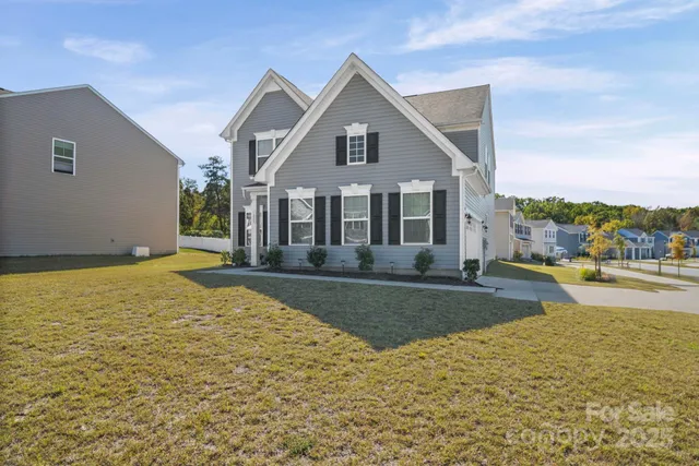 a front view of a house with a yard and ocean view