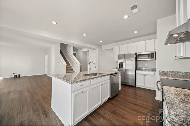 a kitchen with stainless steel appliances granite countertop a stove and a refrigerator