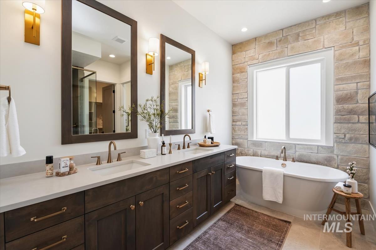 7615 Brown Way Eagle, ID 83714 - Photo 28 of 43 Dual vanity with quartz countertops, dark wood cabinetry, and brushed gold fixtures