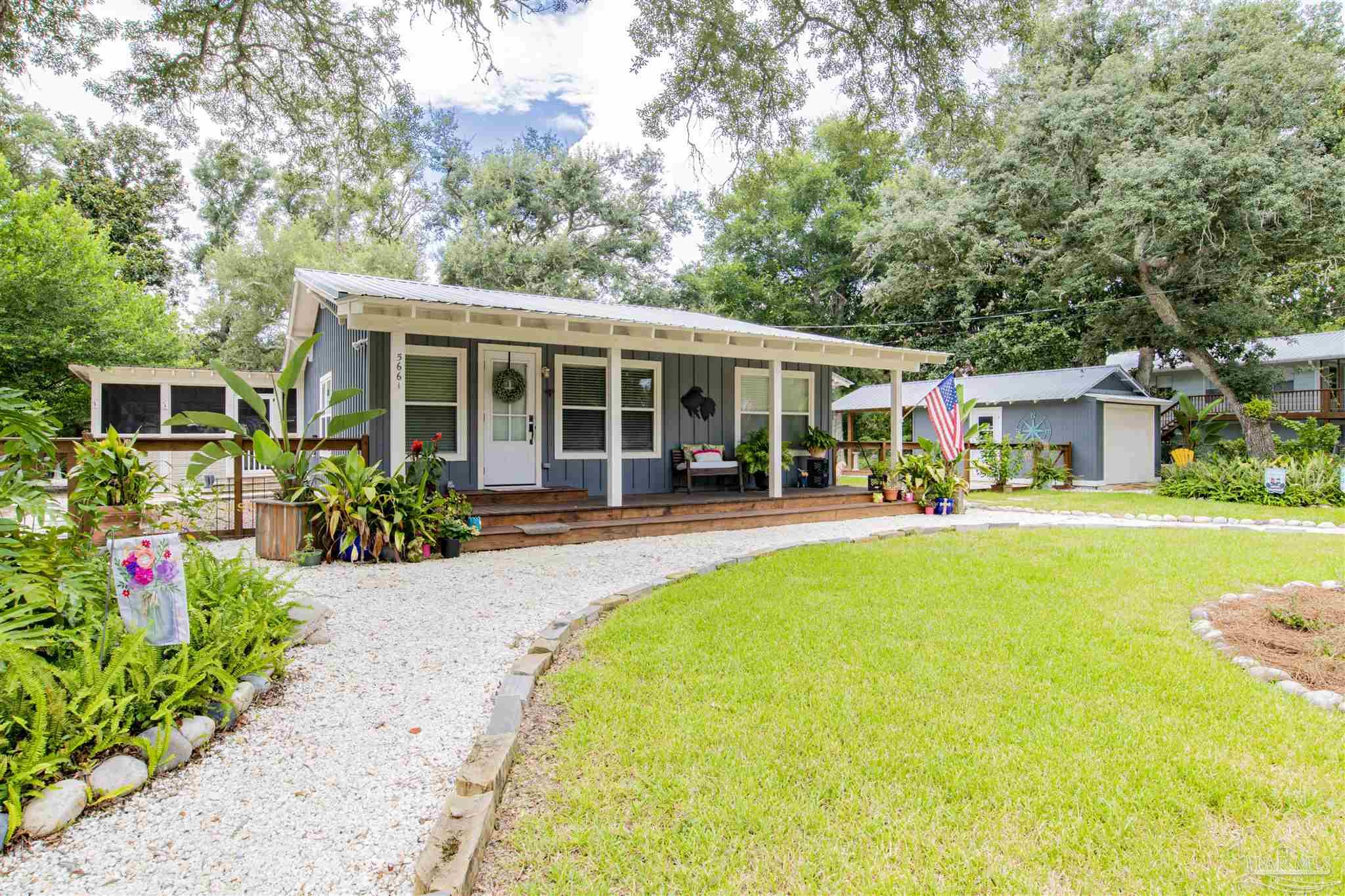 5661 Galvez Road Pensacola, FL 32507 - Photo 31 of 60 a front view of a house with swimming pool and table and chairs