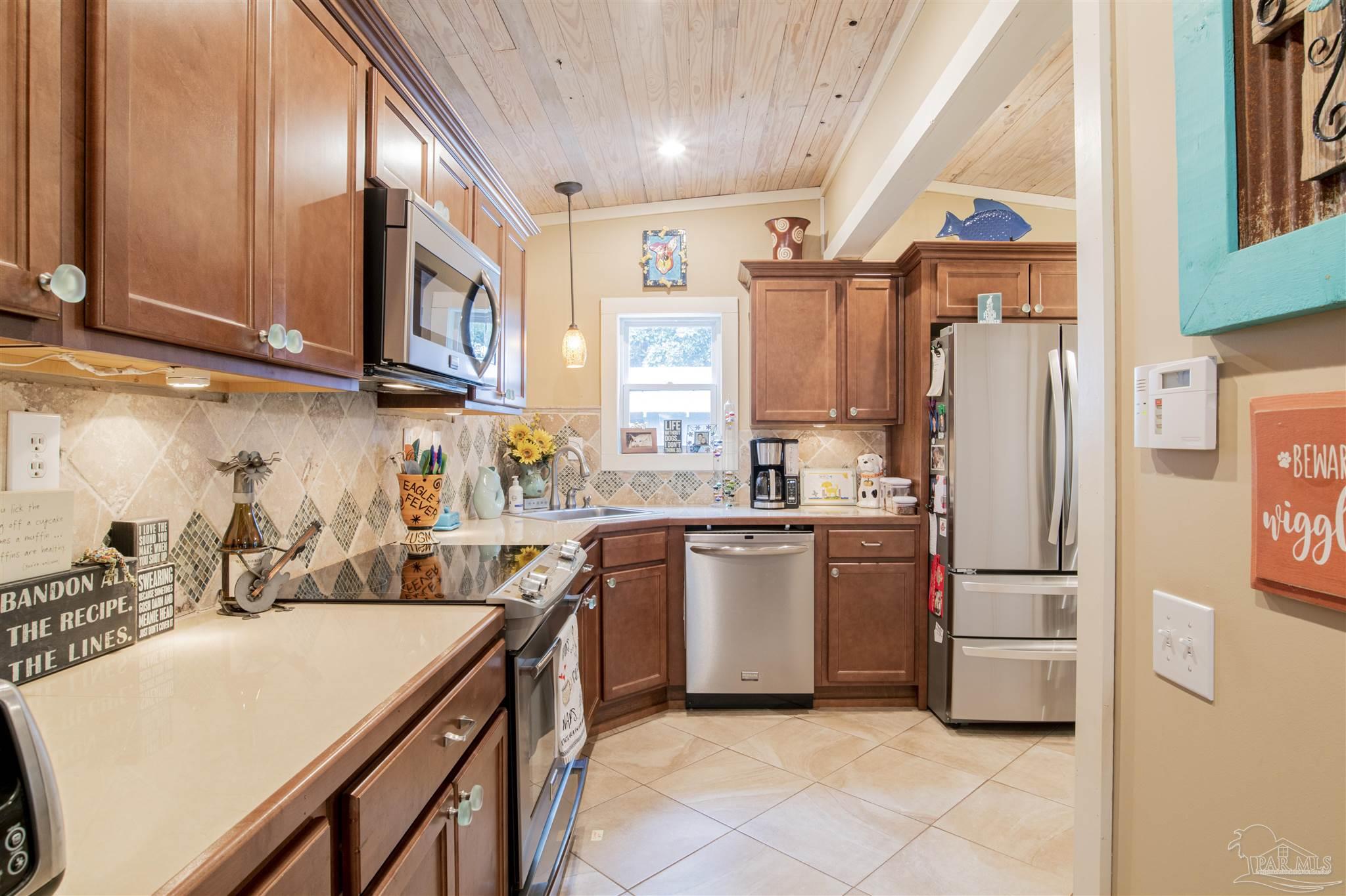 5661 Galvez Road Pensacola, FL 32507 - Photo 48 of 60 a kitchen with stainless steel appliances granite countertop a refrigerator a sink and a stove