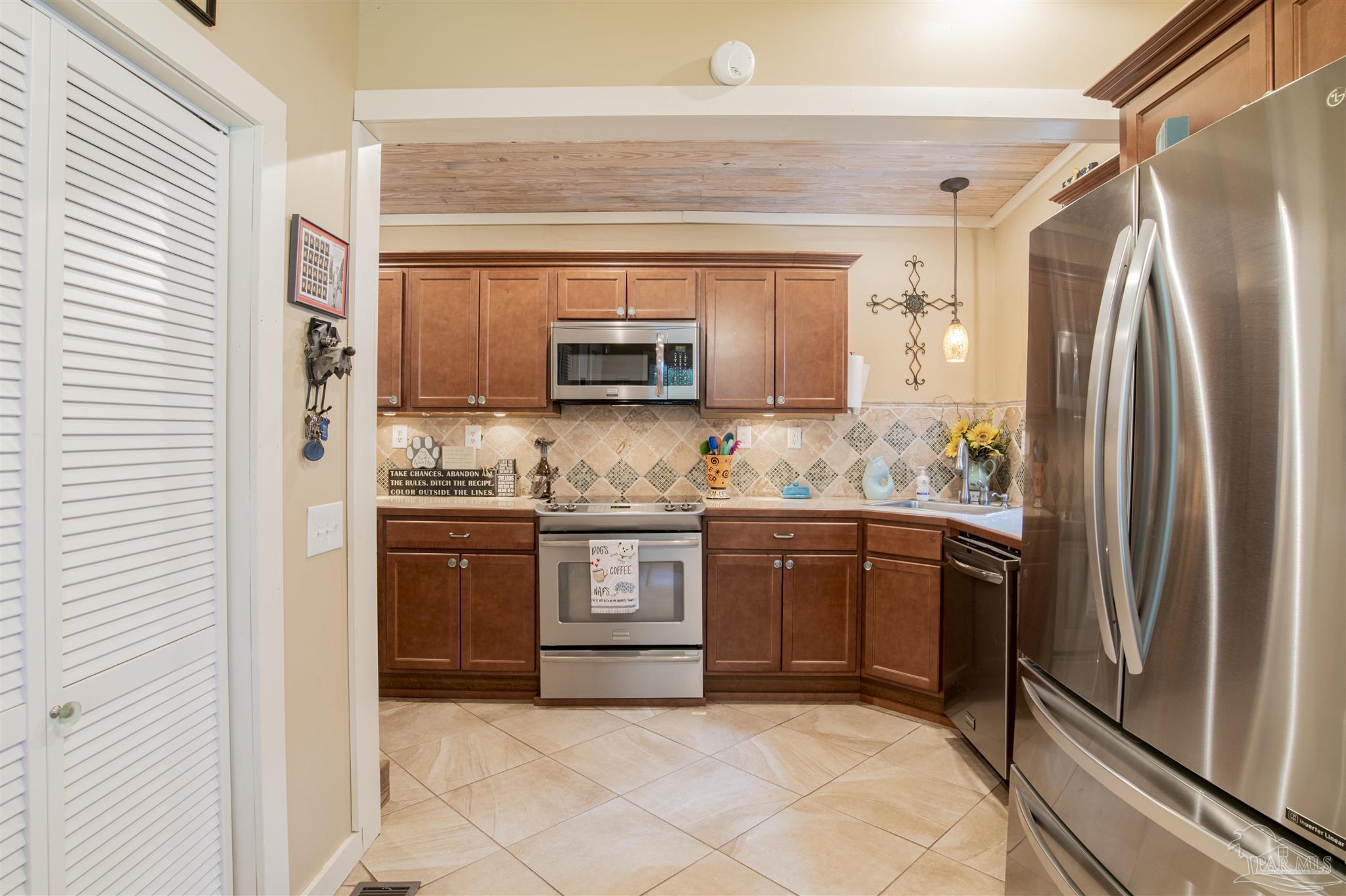 5661 Galvez Road Pensacola, FL 32507 - Photo 50 of 60 a kitchen with stainless steel appliances granite countertop a refrigerator stove and sink