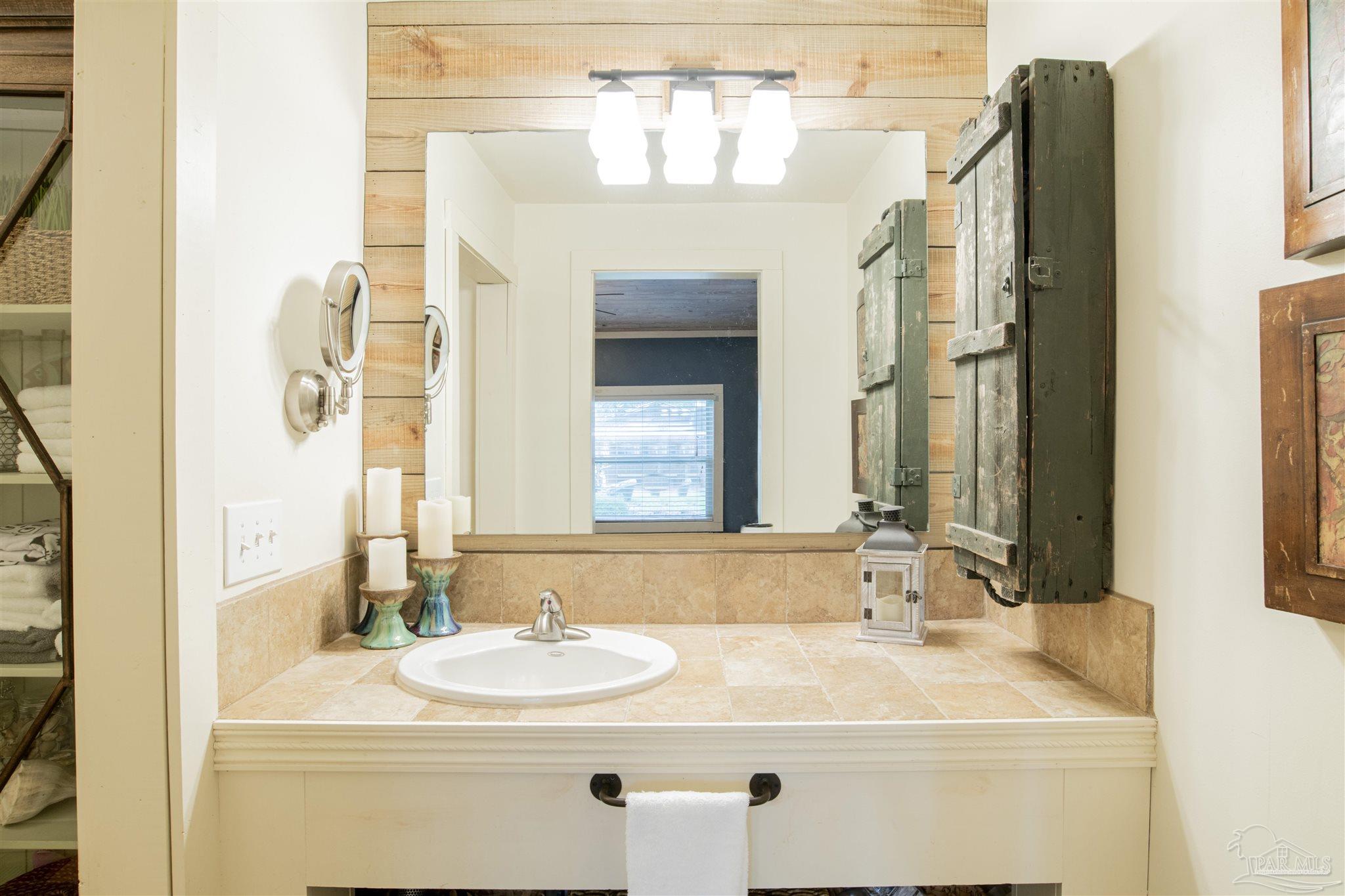 5661 Galvez Road Pensacola, FL 32507 - Photo 52 of 60 a bathroom with a sink and a mirror