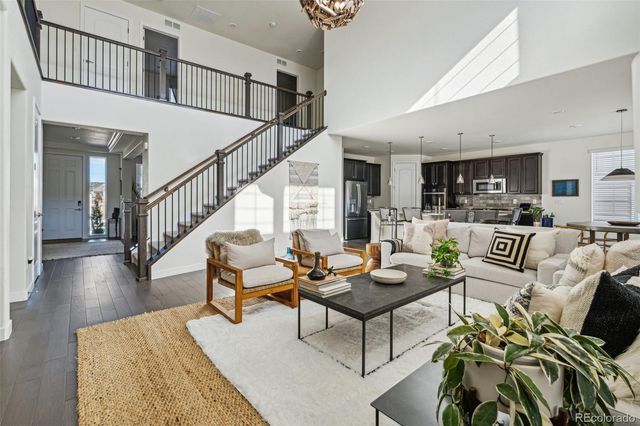 a living room with furniture and a dining table with wooden floor