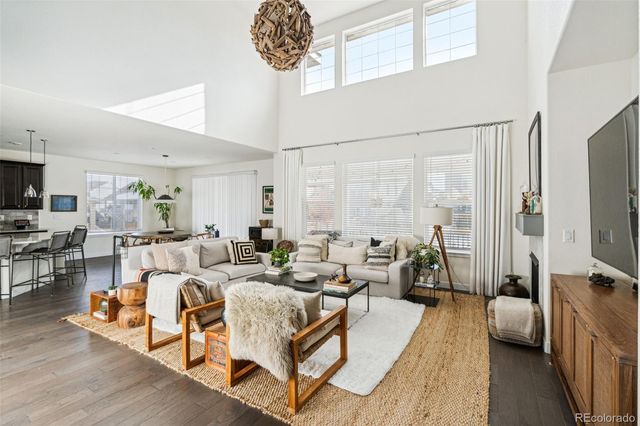 a living room with furniture a large window and a flat screen tv
