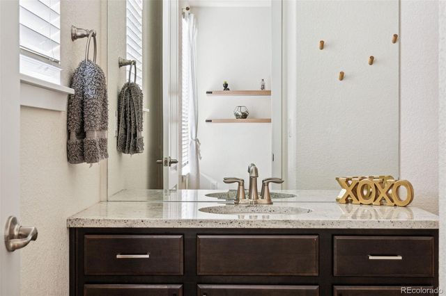 a bathroom with a granite countertop sink and a mirror