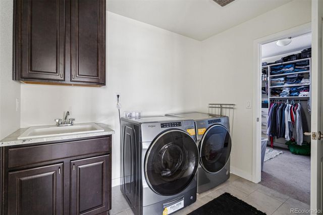 a utility room with sink dryer and washer