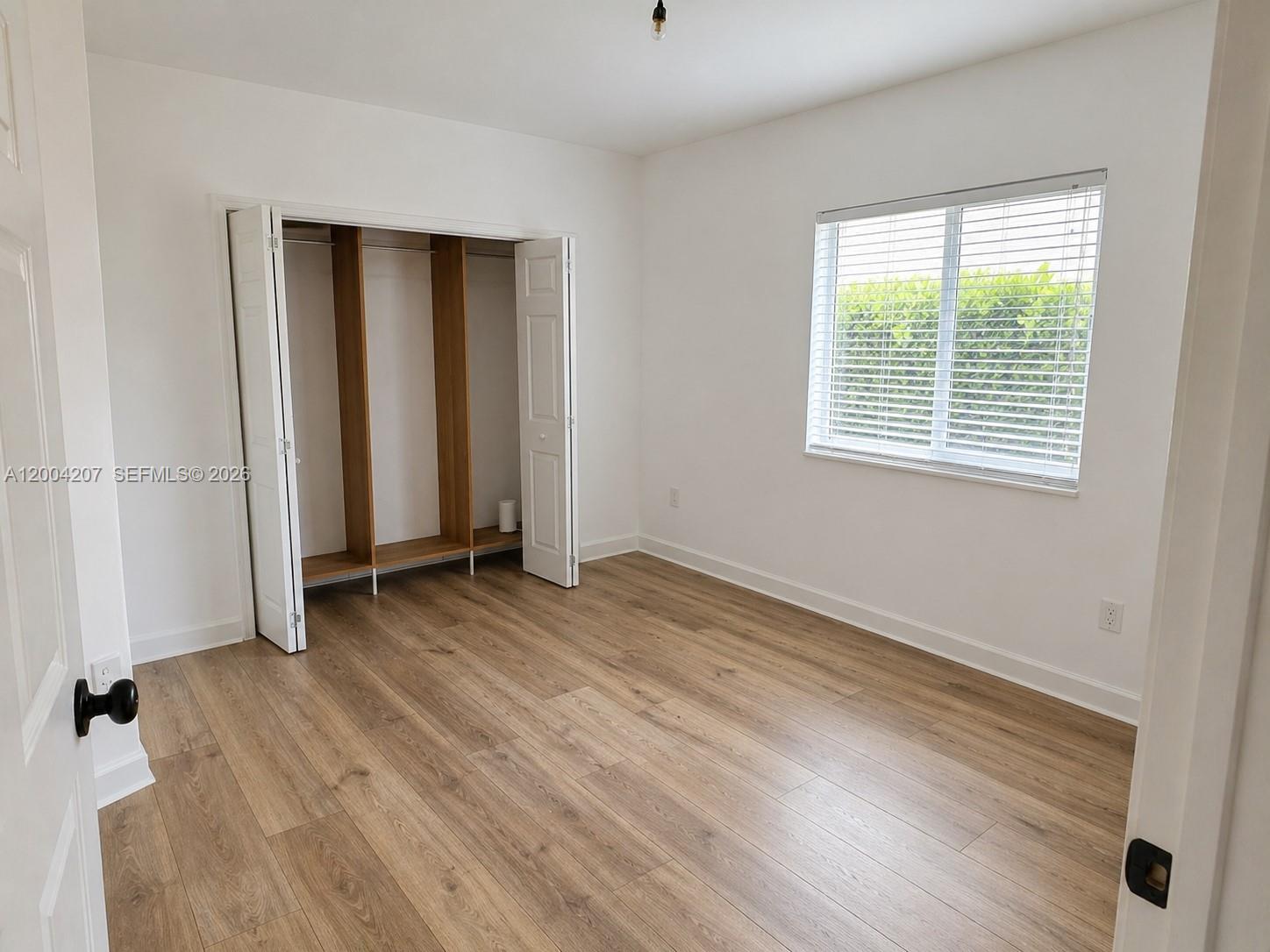 426 Southwest 26th Road Miami, FL 33129 - Photo 8 of 9 an empty room with wooden floor and windows