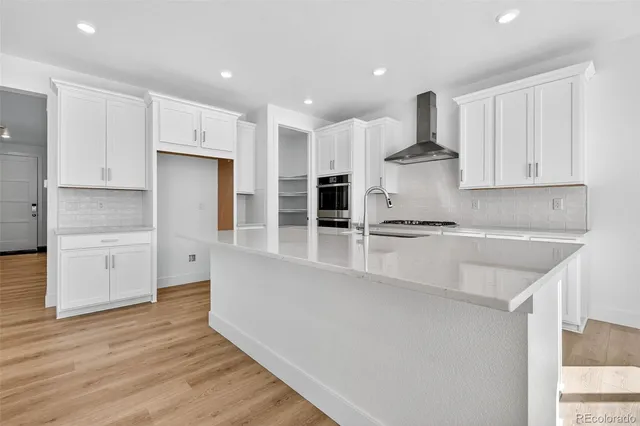 a kitchen with stainless steel appliances granite countertop a sink a stove and a refrigerator