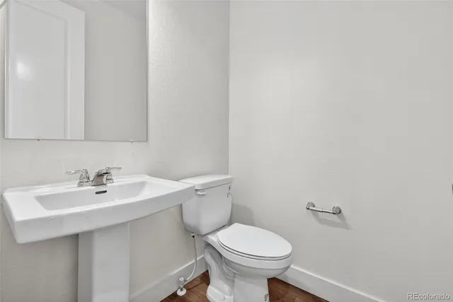 a bathroom with a sink mirror and toilet