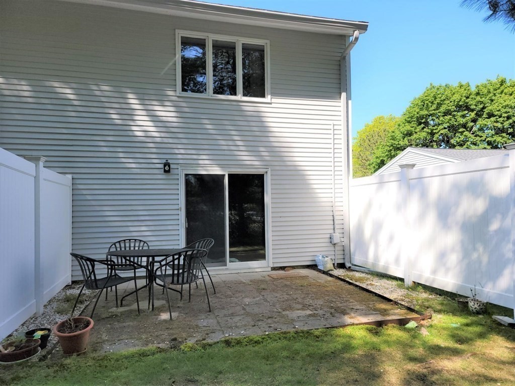 174 Lowell Road, Unit 24 Mashpee, MA 02649 - Photo 3 of 16 a backyard of a house with table and chairs