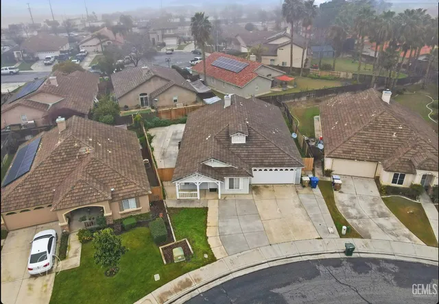an aerial view of residential houses with outdoor space and parking