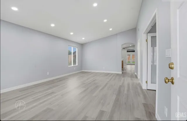 a view of a big room with wooden floor and windows
