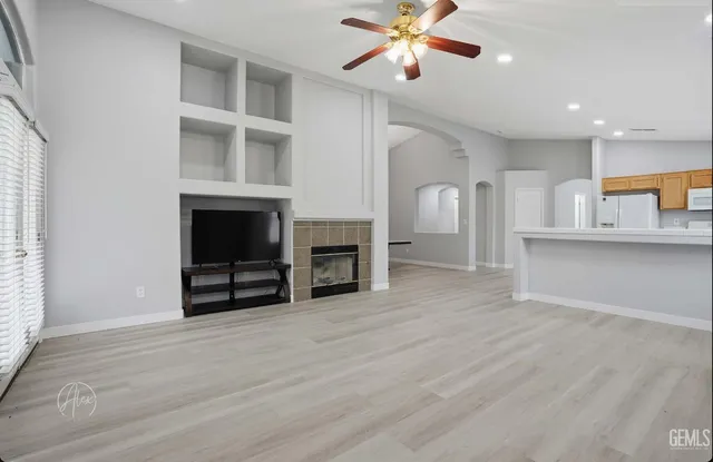 a view of an empty room with a fireplace and a window