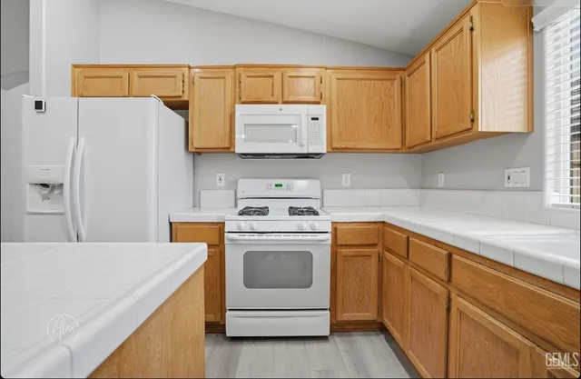a kitchen with white cabinets and white appliances