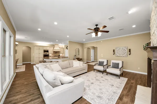 a kitchen with stainless steel appliances granite countertop a refrigerator a stove and a sink with wooden floor