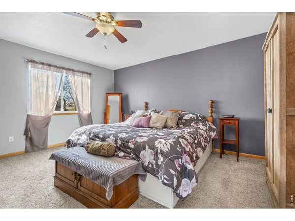 a bedroom with a bed a chandelier and a window