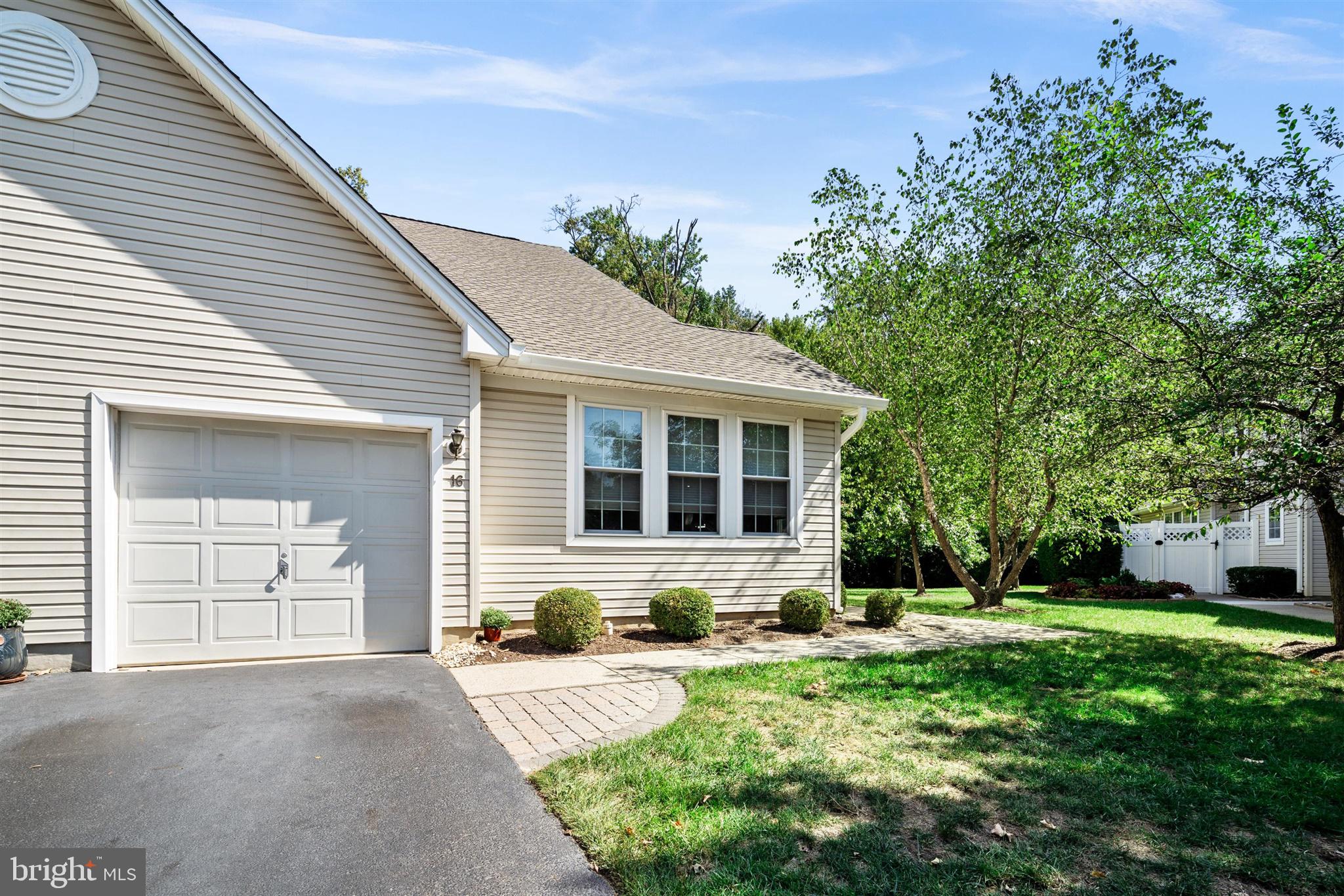 a front view of a house with yard and green space