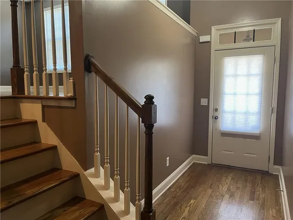 a view of a hallway with wooden floor and staircase