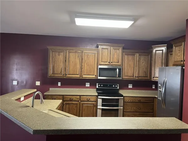 a kitchen with kitchen island granite countertop a stove microwave and refrigerator